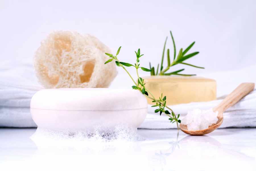 Produtos para banho de ervas para abrir caminho: bucha, sabonete, sal grosso e ervas.