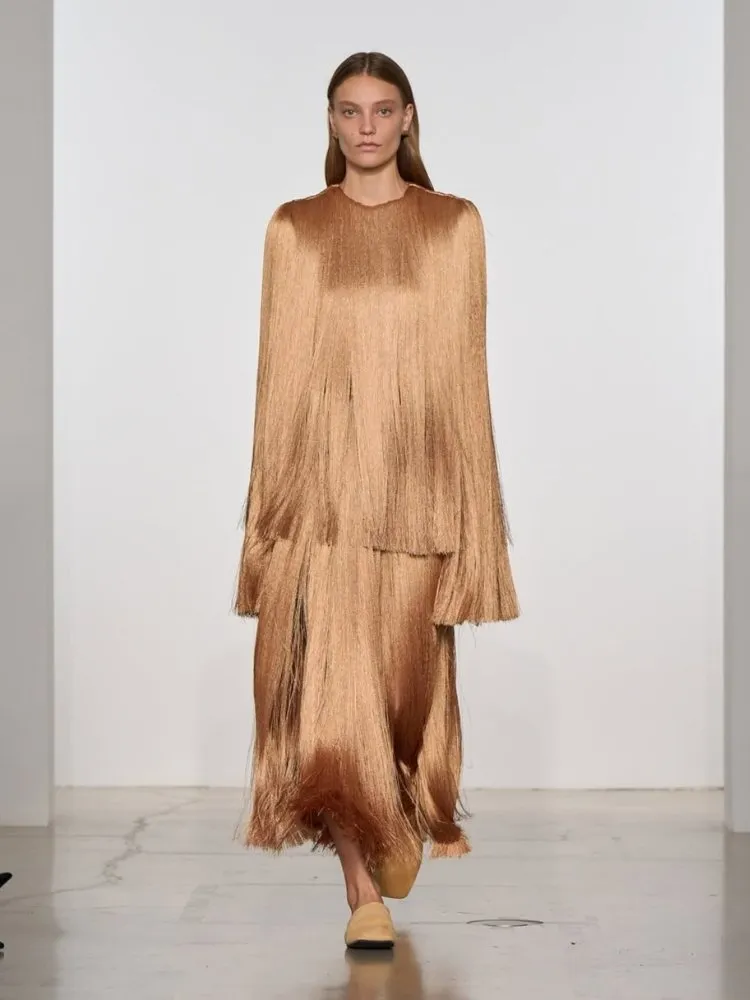 Modelo usando vestido de franjas dourado Calvin Klein, uma das tendências da Semana de Moda de Nova York