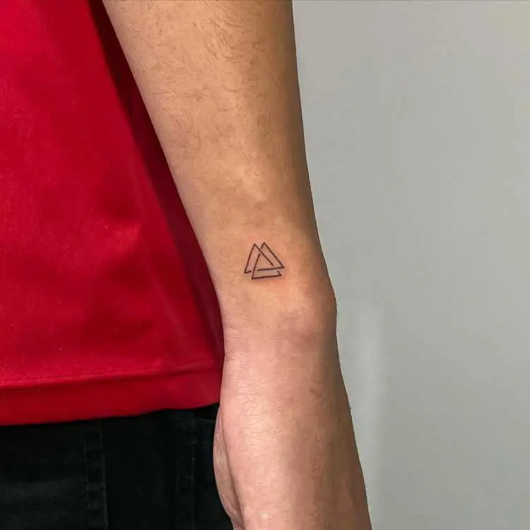 símbolo de três triângulos interligados tatuados no pulso
