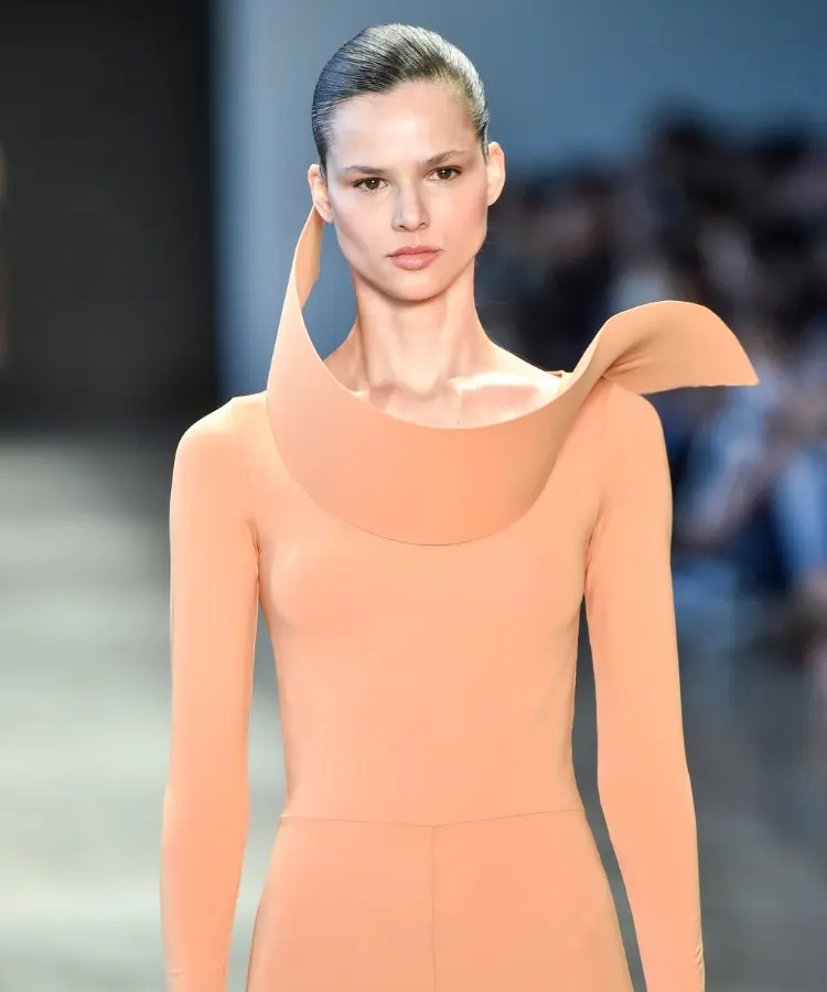 Foto de modelo na passarela usando body rosa com gola geométrica