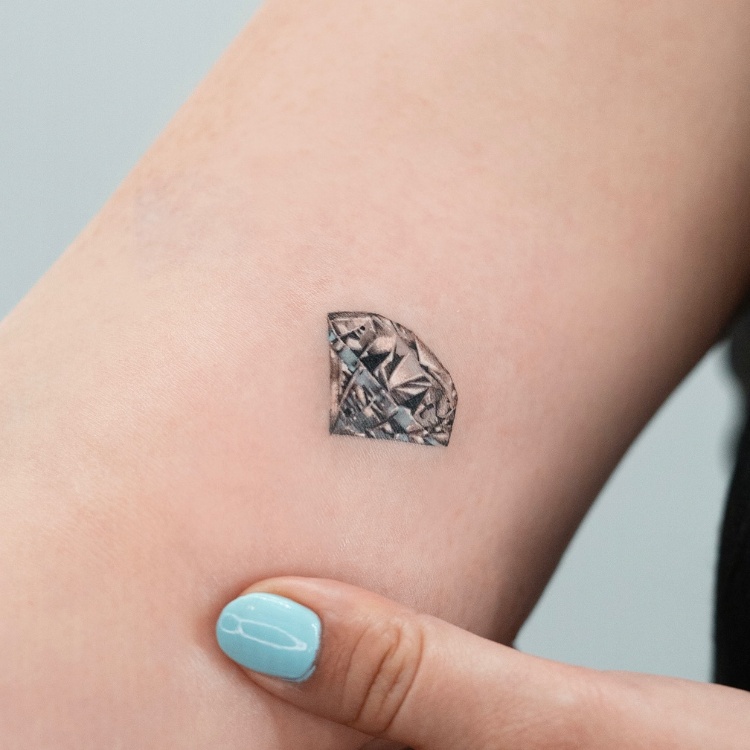 Tatuagem pequena de diamante em realismo 