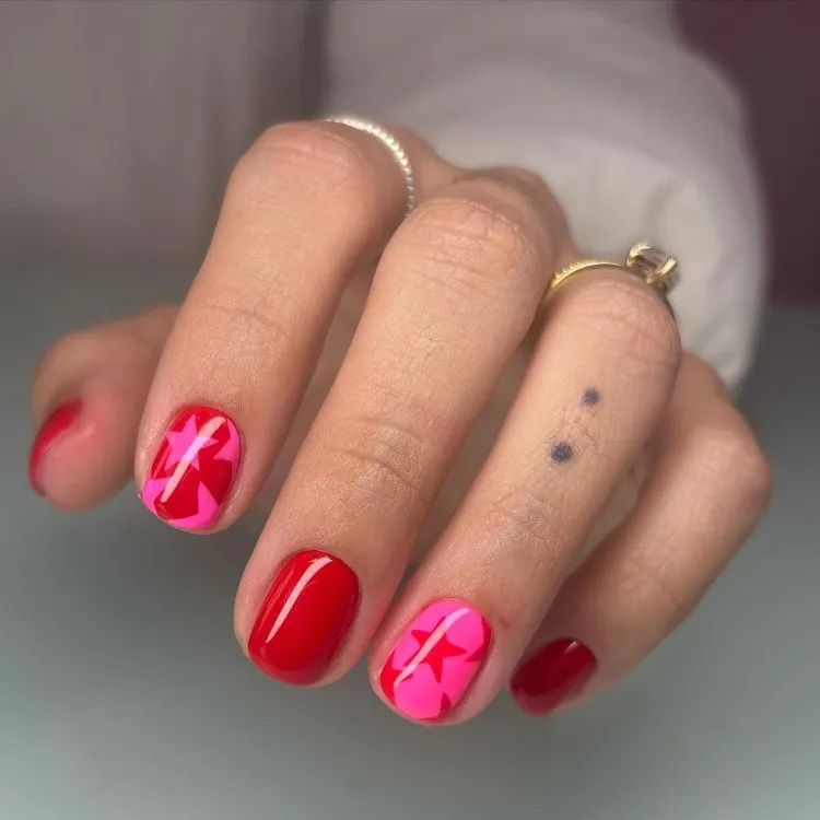 Unhas curtas vermelhas e rosas com estrelas 