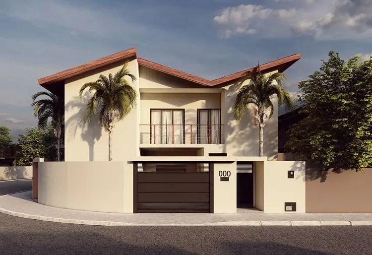 Casa de dois pavimentos com telhado em duas águas bem inclinadas, fachada em tons neutros e portão de garagem metálico preto. Varanda com guarda-corpo metálico na frente. Palmeiras e plantas ao redor complementam o paisagismo moderno e tropical.