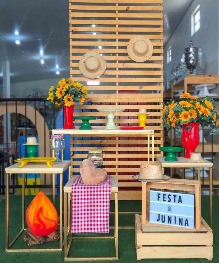 Ideia de vitrine com mesas, chapéus, flores de girassol, para loja de coisas de decoração de aniversário