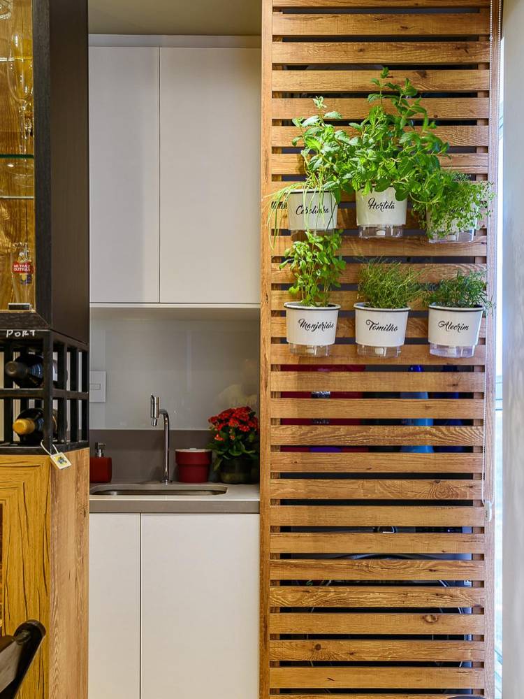 Lavanderia com painel ripado e vasos com horta
