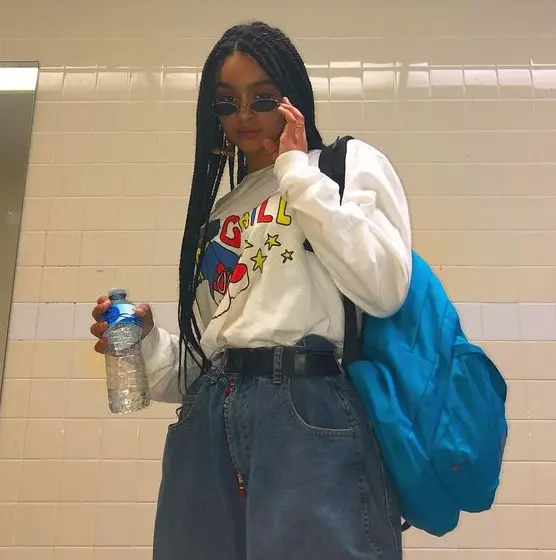 Look vintage com calça, cinto, blusa e mochila