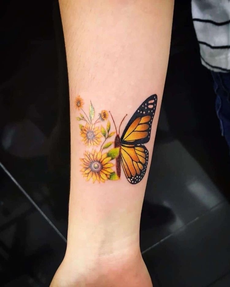 Tatuagem no braço de borboleta amarela com asa de girassóis 
