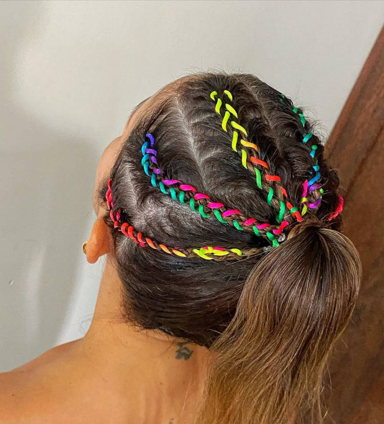 Tranças com fitas coloridas entrelaçadas nas mechas.
