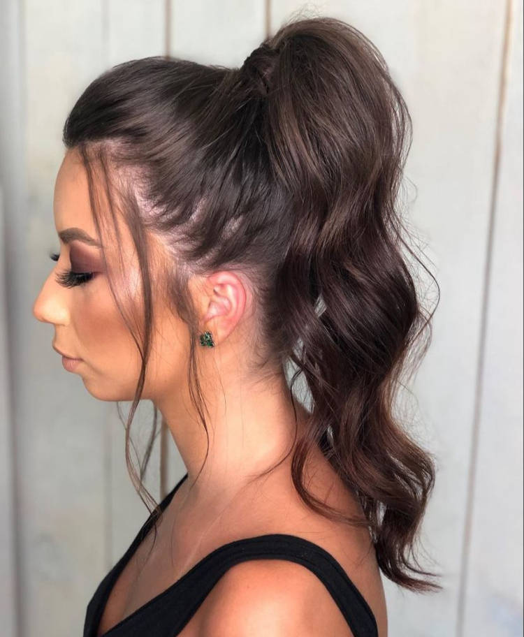 Mulher de pele clara com cabelo castanho em rabo de cavalo com babyliss