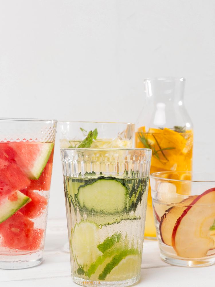 Copos com água saborizadas com frutas.