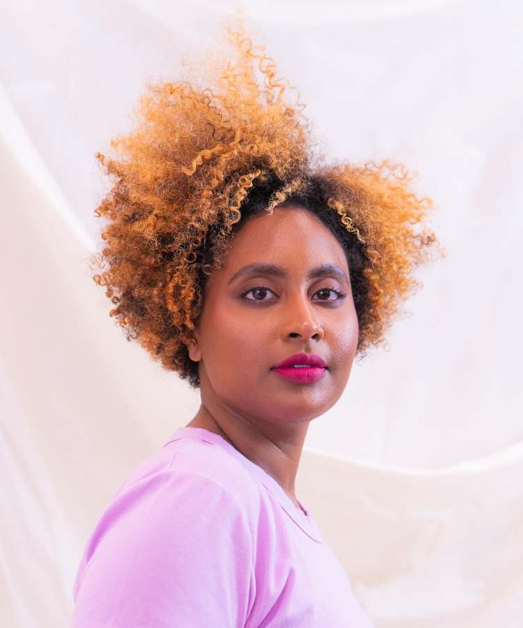 Corte em camadas mulher com cabelo castanho e loiro crespo