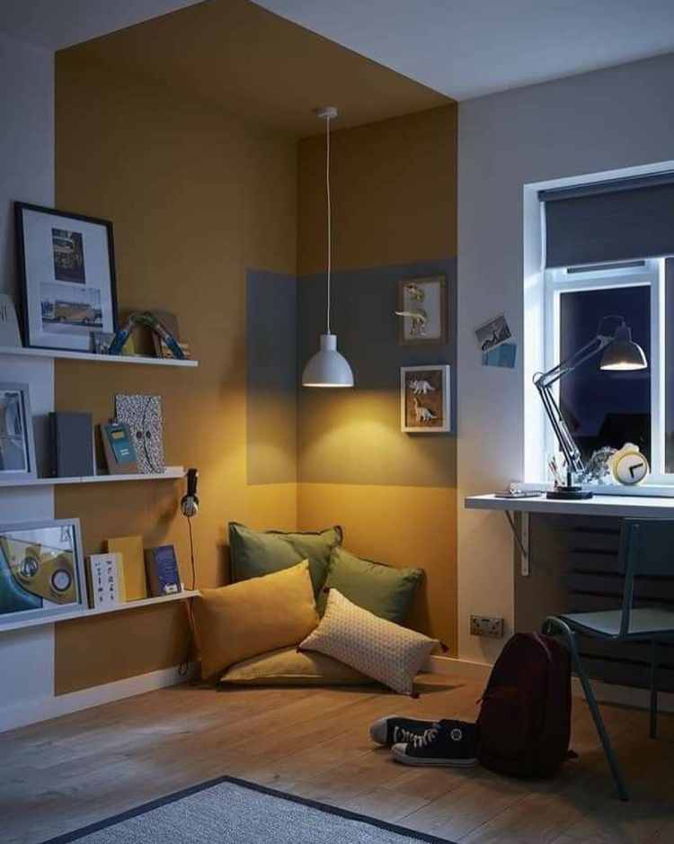 quarto com canto de almofadas no chão e iluminação baixa