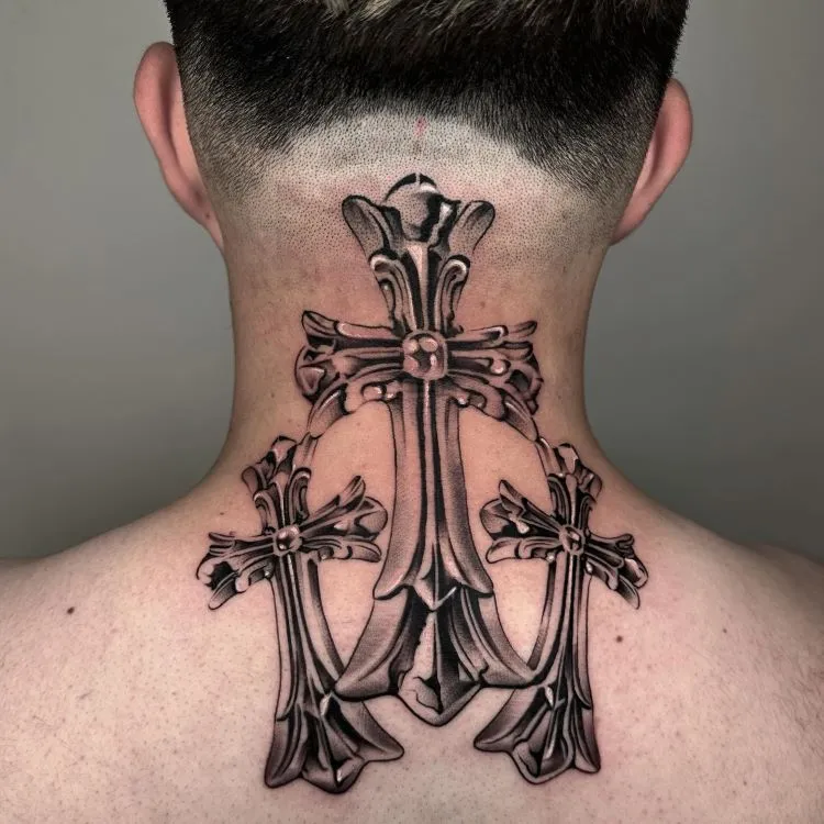 A imagem mostra uma pessoa de costas com cabelo curto. Ela tem uma tatuagem no pescoço de três cruzes ornamentadas, detalhadas em preto e cinza. A maior cruz está no centro, com duas menores em cada lado, cobrindo toda a parte de trás do pescoço até os ombros.


