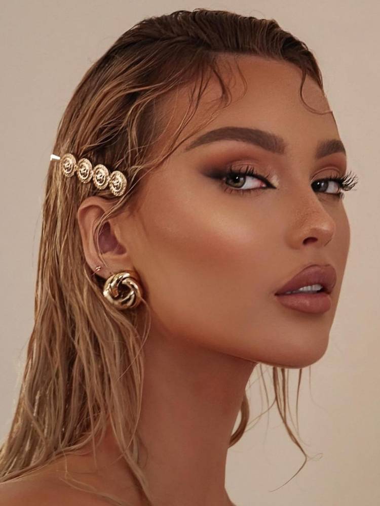 Mulher de pele e cabelo claros com wet hair e presilha. 