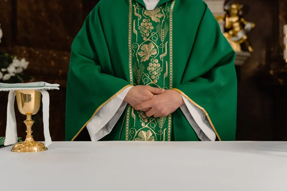 padre com batina verde pronto para celebrar a missa