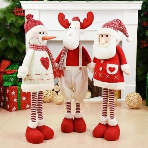Enfeites de papai Noel, boneco de neve e rena perto de lareira