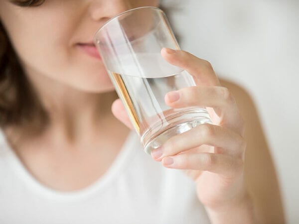 Foto de mulher tomando água - Infecção urinária