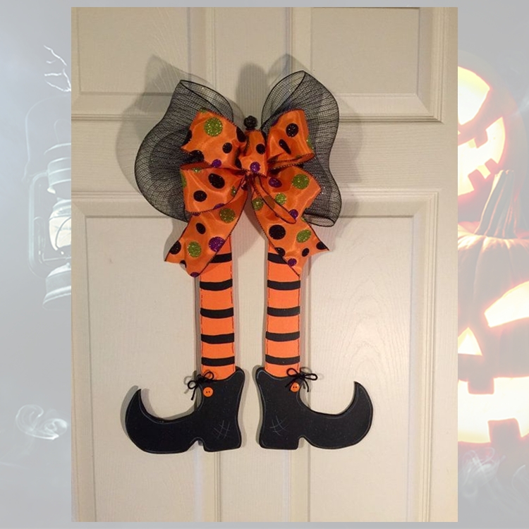 Foto de porta decorada com guirlanda de pernas de bruxa em tons de laranja e preto 