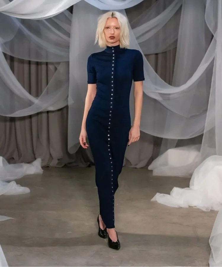 Foto de modelo usando vestido azul com botões brancos, uma das tendências da NYFW Outono Inverno 2026