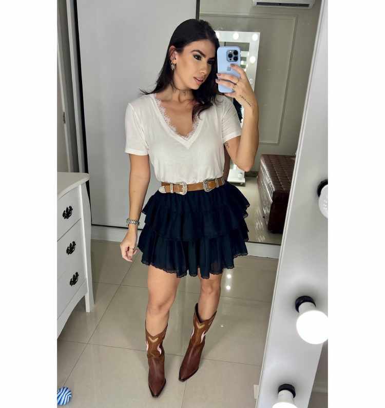mulher com blusa branca e saia preta de babado