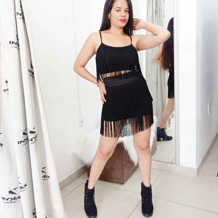 mulher com conjunto de saia e top preto de franja