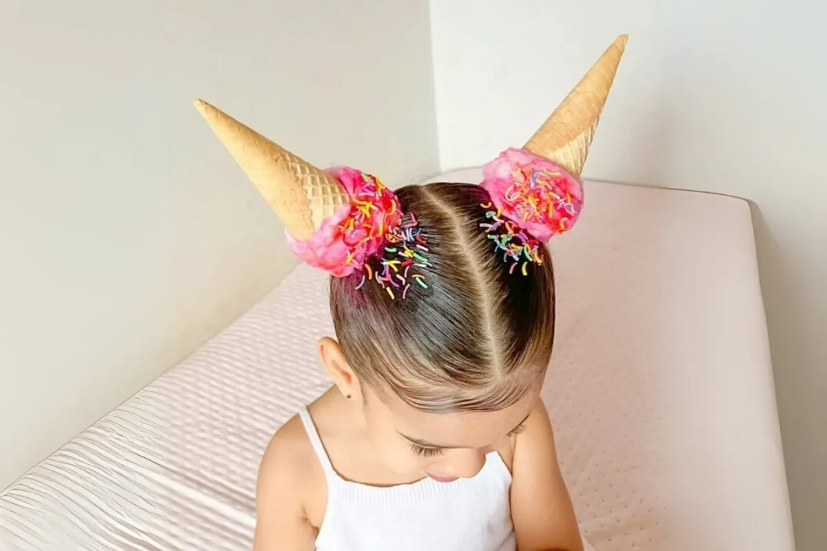 Foto de menina com cabelo maluco imitando duas casquinhas de sorvete