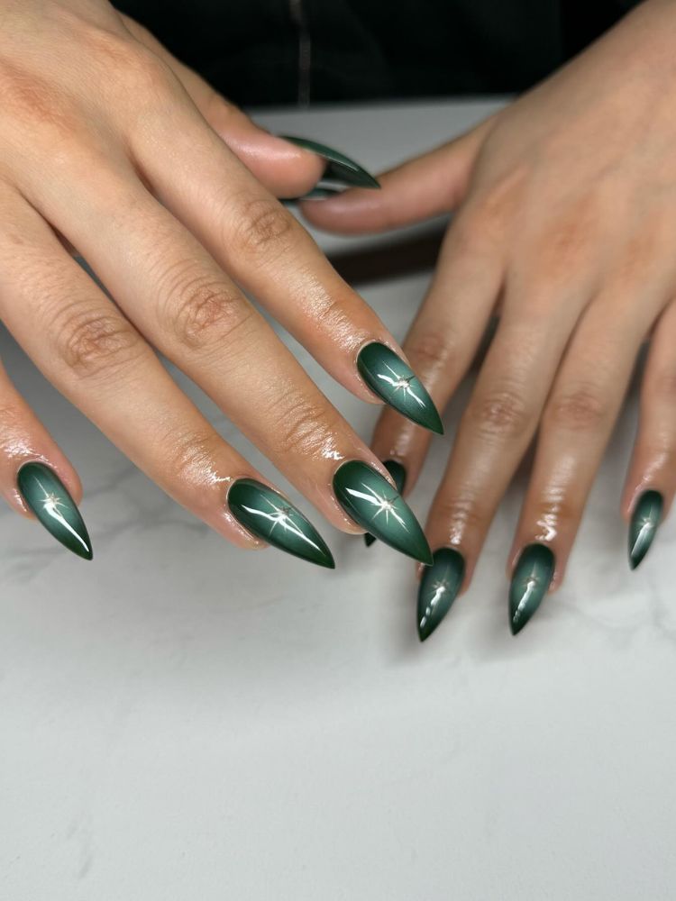Pessoa de pele clara com unha stiletto estilo aura nail em verde claro e escuro 