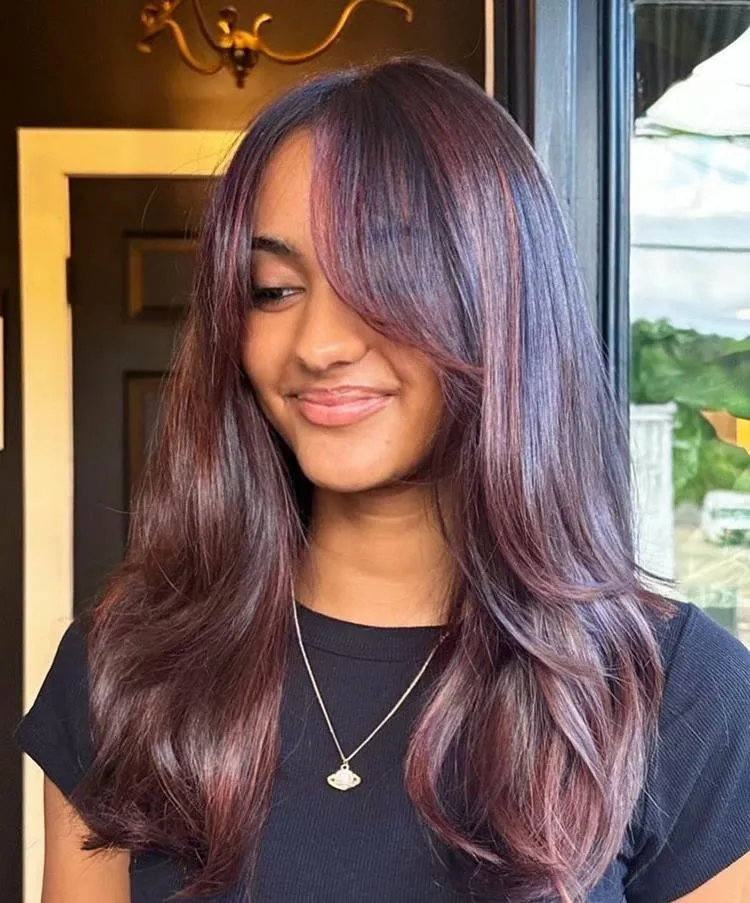 mulher de cabelo médio avermelhado e franja cortininha