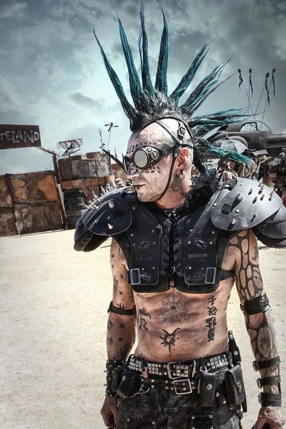 Homem fantasiado de punk, com cabelo para cima, óculos, armaduras com espinhos e mais 