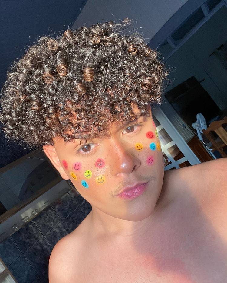 Homem com make fofa, carinhas coloridas e sardinhas