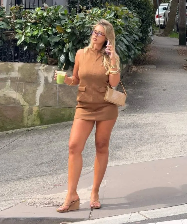 Foto de mulher loira usando vestido de camurça curto com sandália de dedo e salto de cortiça