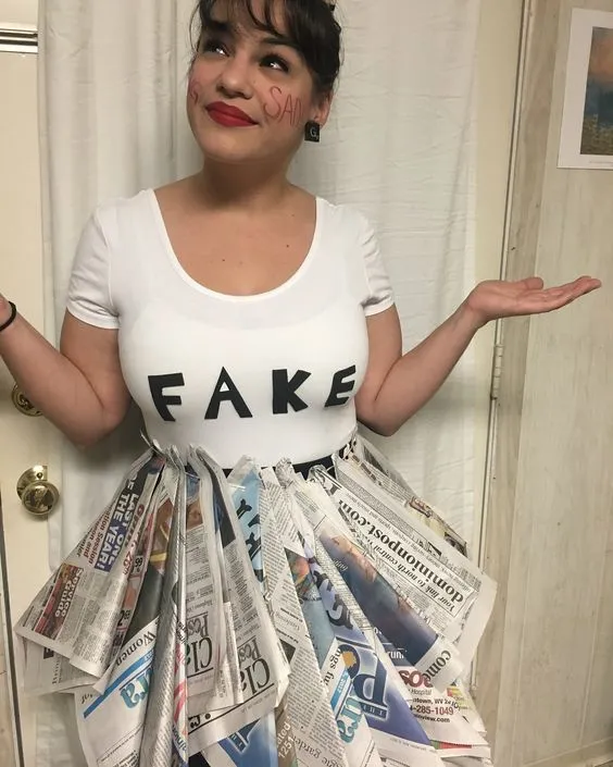 Mulher de pele clara com blusa branca escrito "Fake", saia de jornal 
