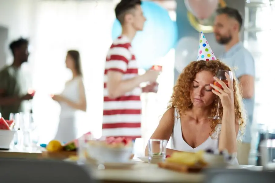 Mulher triste em uma festa de confraternização.