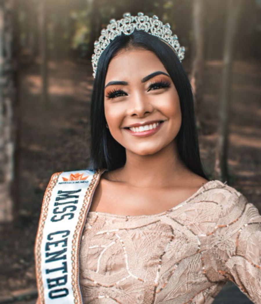 A candidata do centro de São Paulo posa com um vestido bege texturizado e a faixa de Miss