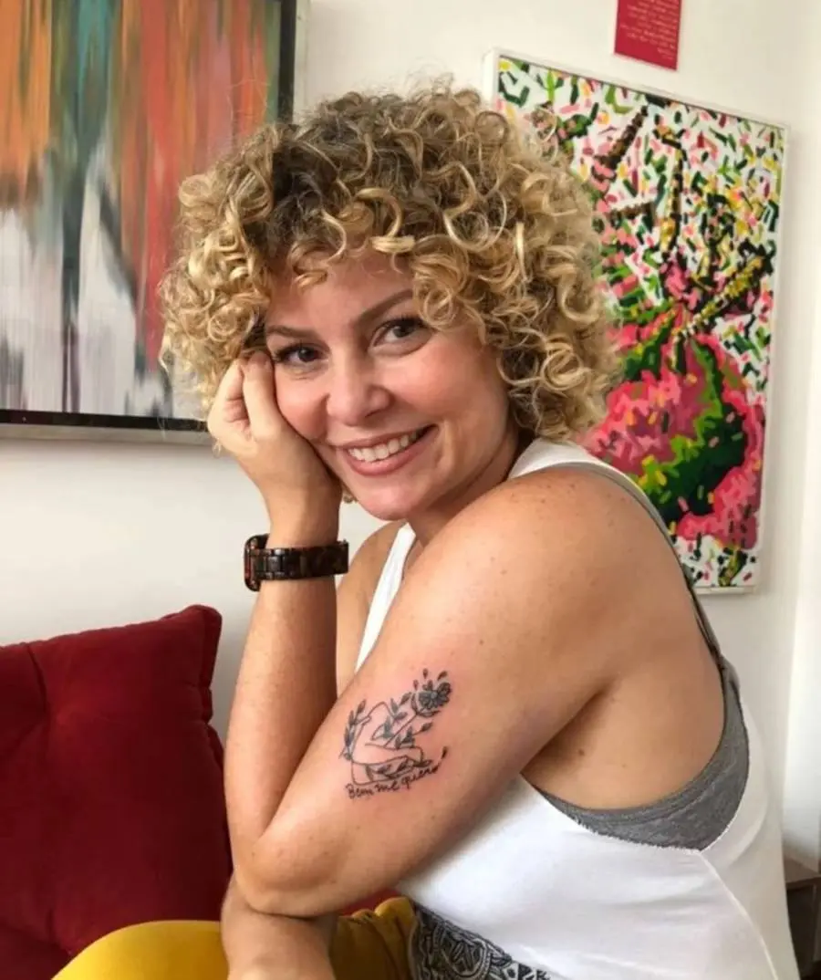Foto de Barbara Borges com a mão no rosto e a tatuagem "bem me quero"