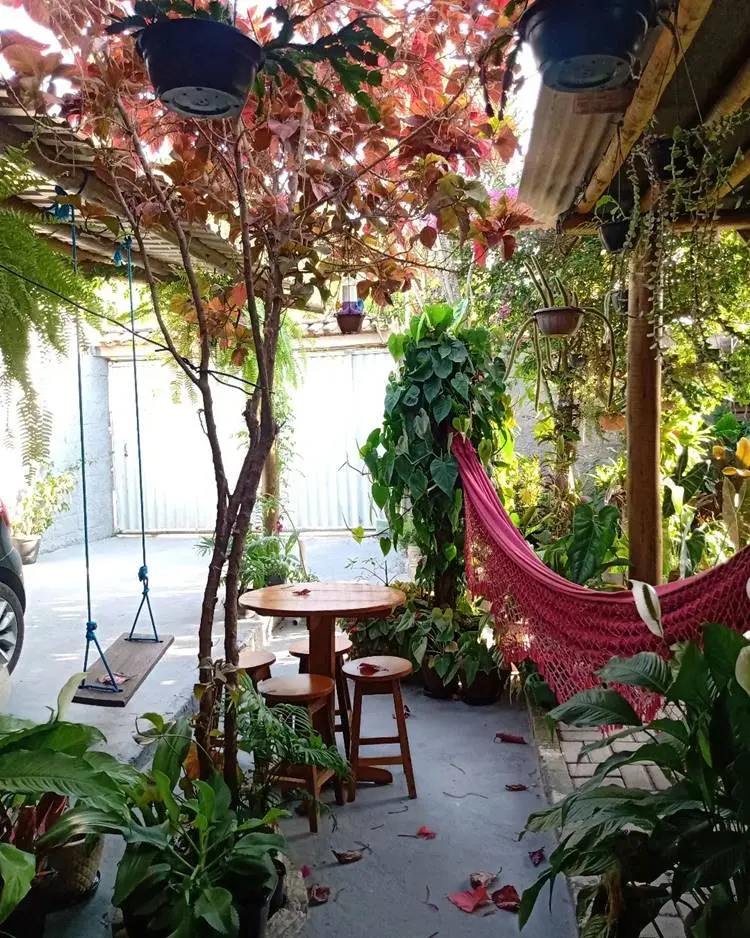 Rede em jardim com plantas, mesa e balanço