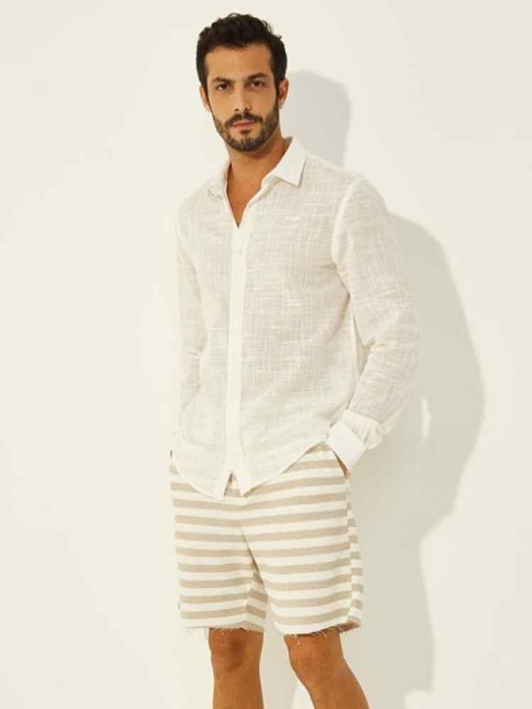 Look para homem virada do ano: camisa de botões de linho + bermuda listrada branco e bege.