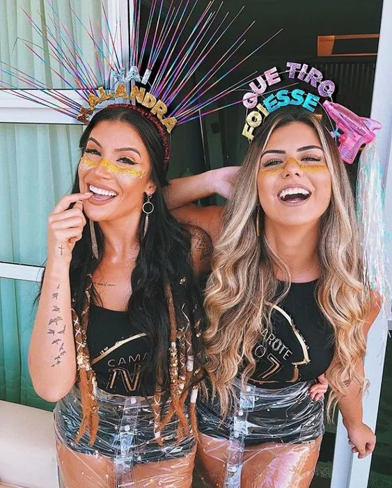 Boca Rosa e Mayara usando body pretos, saia transparente e tiaras como "vai malandra" e "que tiro foi esse"