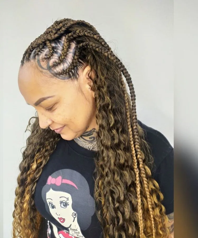 Trança nagô em cabelo cacheado, mulher possui tatuagem no couro cabelo e usa camiseta da branca de neve