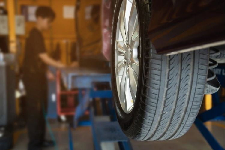 Foto de um carro/ pneu do carro em manutenção na oficina mecânica. carro usado procedência