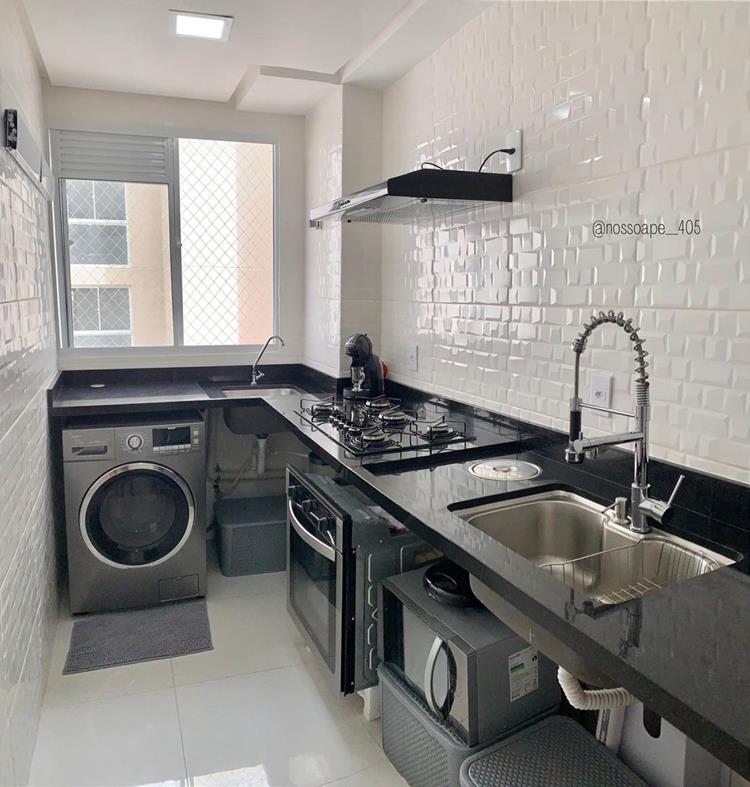 foto de cozinha integrada com lavanderia, com máquina de lavar, pias, forno, micro-ondas, fogão cooktop, pedras preta e azulejos brancos