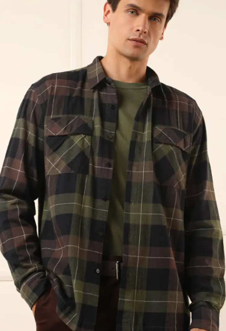 Homem usando camisa xadrez verde musgo, preta e marrom + camiseta verde musgo + calça marrom