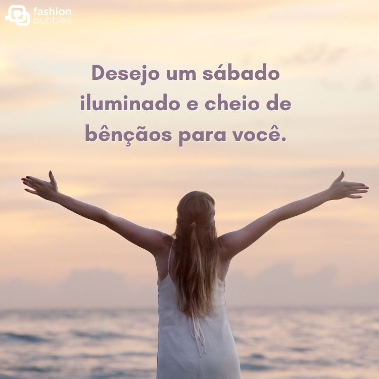 Mulher loira de pele de costas para a foto e de frente para o mar com frase " Desejo um sábado iluminado e cheio de bênçãos para você."