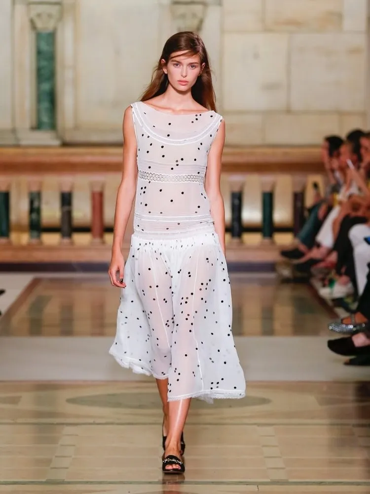 Foto de modelo usando vestido com estampa de bolinhas Tory Burch, uma das tendências da Semana de Moda de Nova York 2025