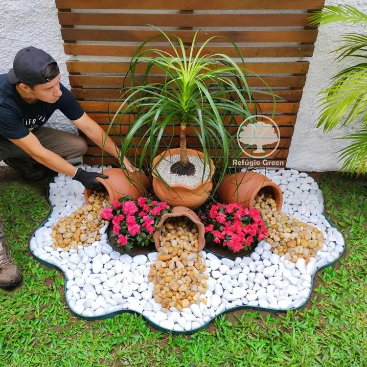 Jardim criativo com vasos e pedras derramando e flores