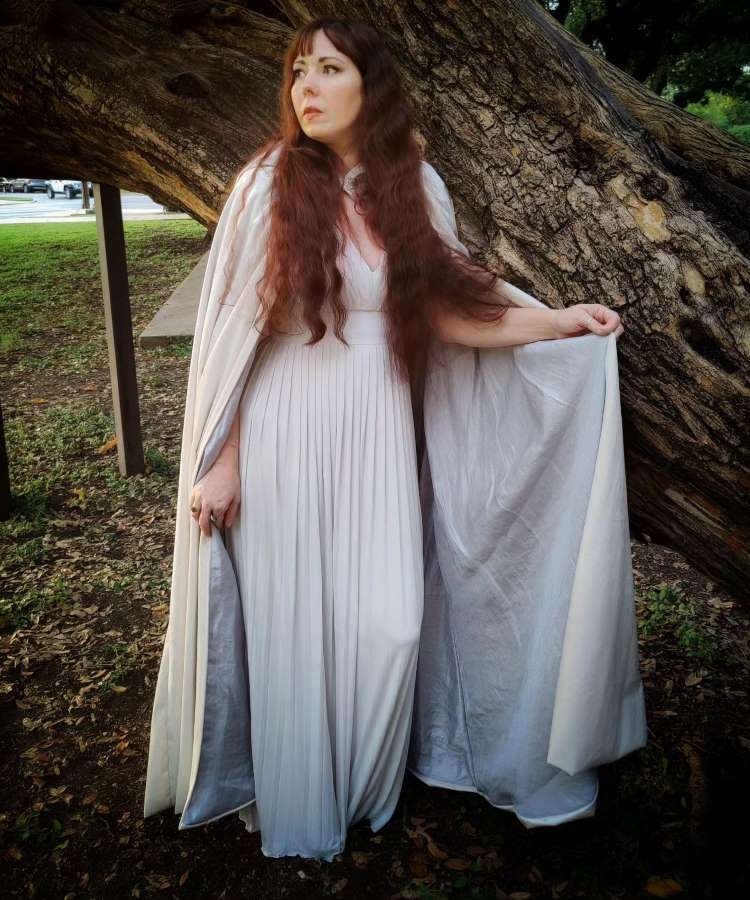 Mulher com vestido branco e capa branca de Halloween