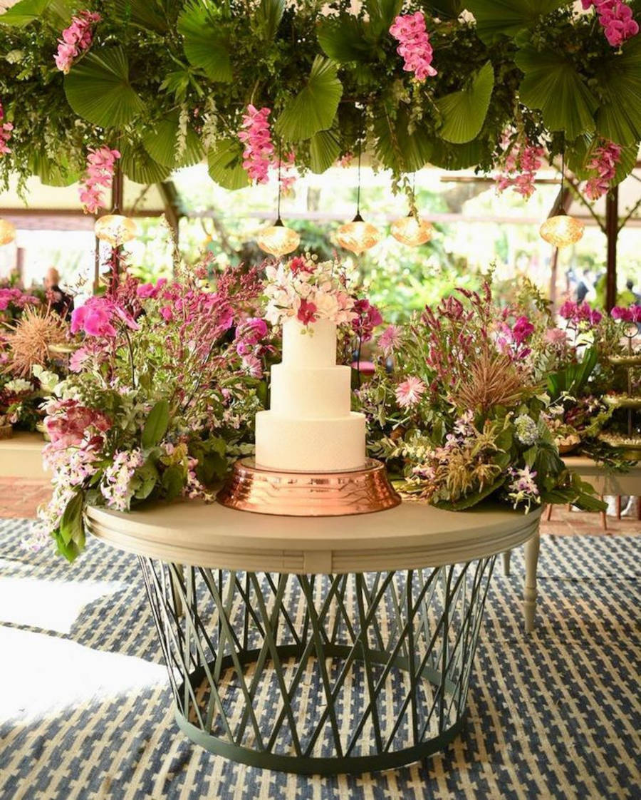 Mesa apenas com bolo e flores.