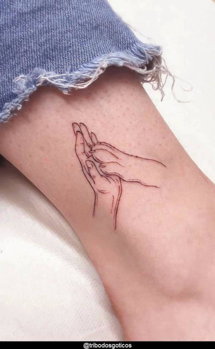 Tatuagem de mão e pata em fineline em pele clara