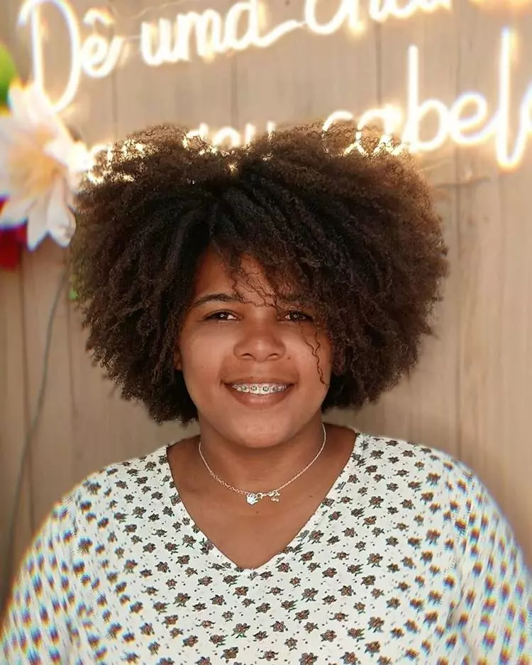 Corte em camadas mulher com cabelo castanho crespo