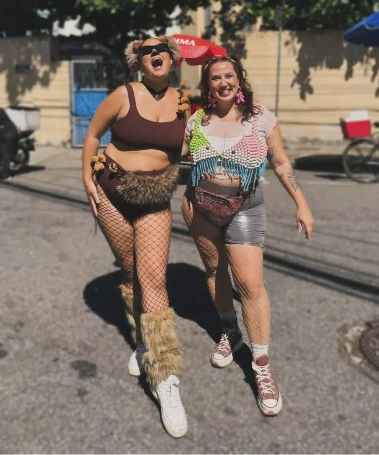 Duas amigas usando fantasia de capivara e de peixe em bloco de Carnaval